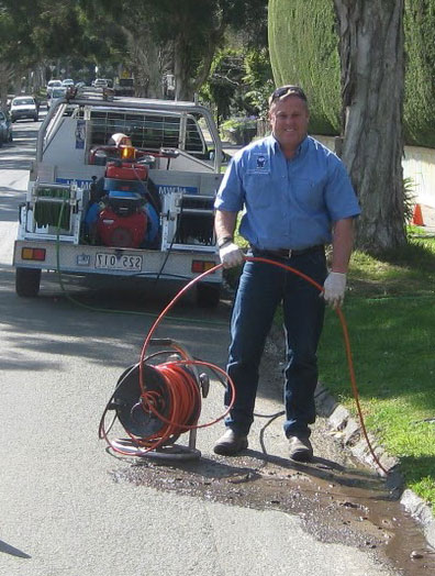 Morgan hill plumbing contracor runs drain cleaning equipment at a curb